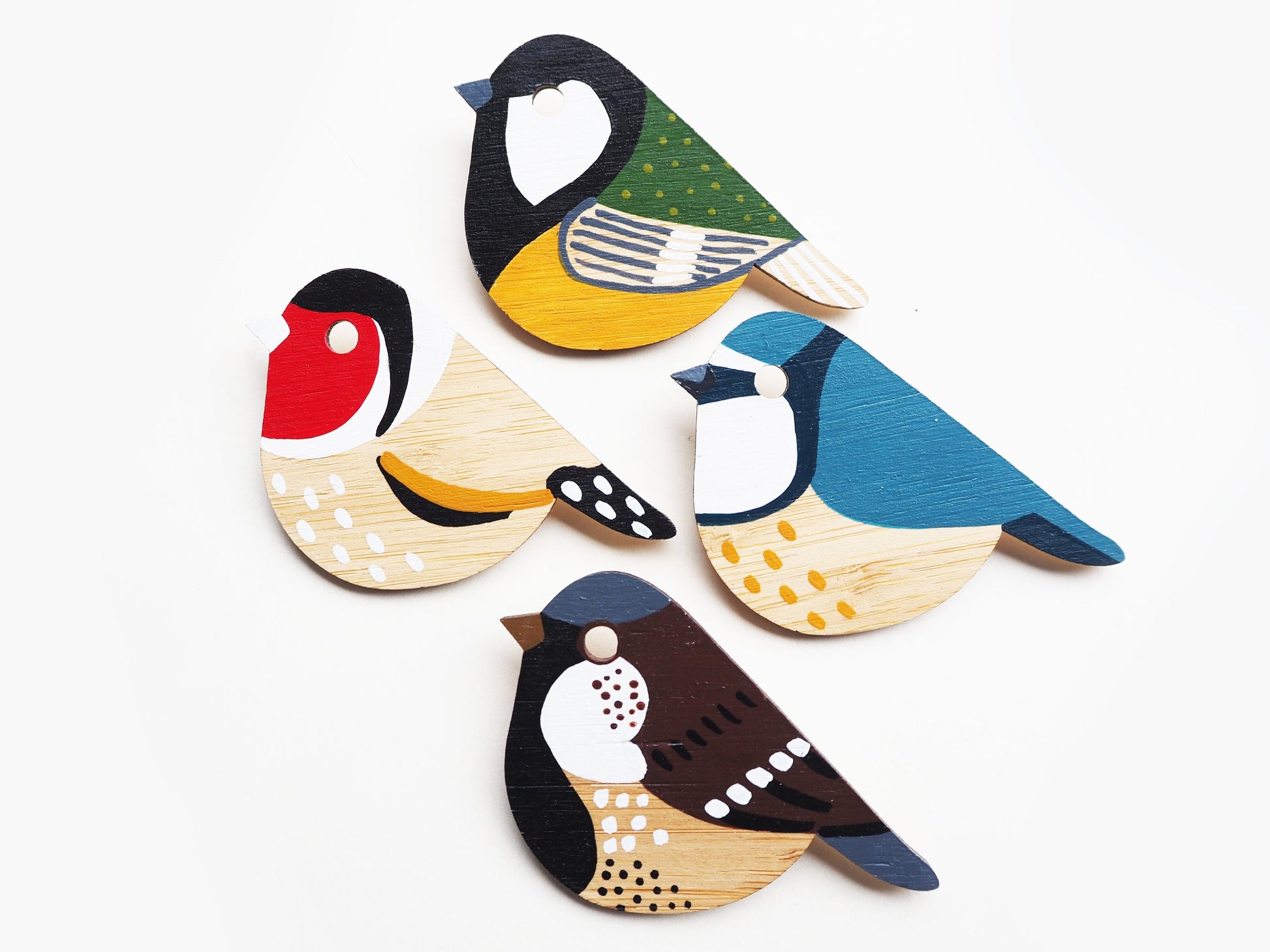 Hand-painted bamboo bird brooches laser cut from FSC bamboo. 
