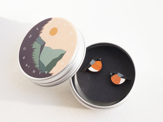 Hand painted bullfinch earrings displayed in a round tin with a colorful lid, showcasing the unique garden bird designs.