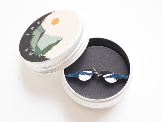 Magpie bamboo earrings displayed in a decorative tin, showcasing hand-painted magpie design with vibrant colors.