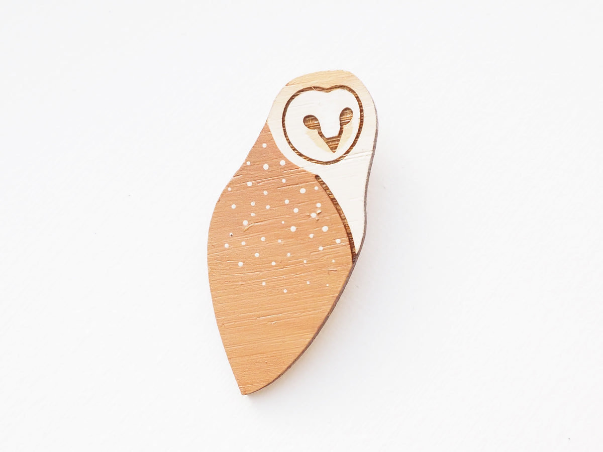 Hand painted barn owl brooch illustration on bamboo, featuring dotted details and soft cream and beige colors.